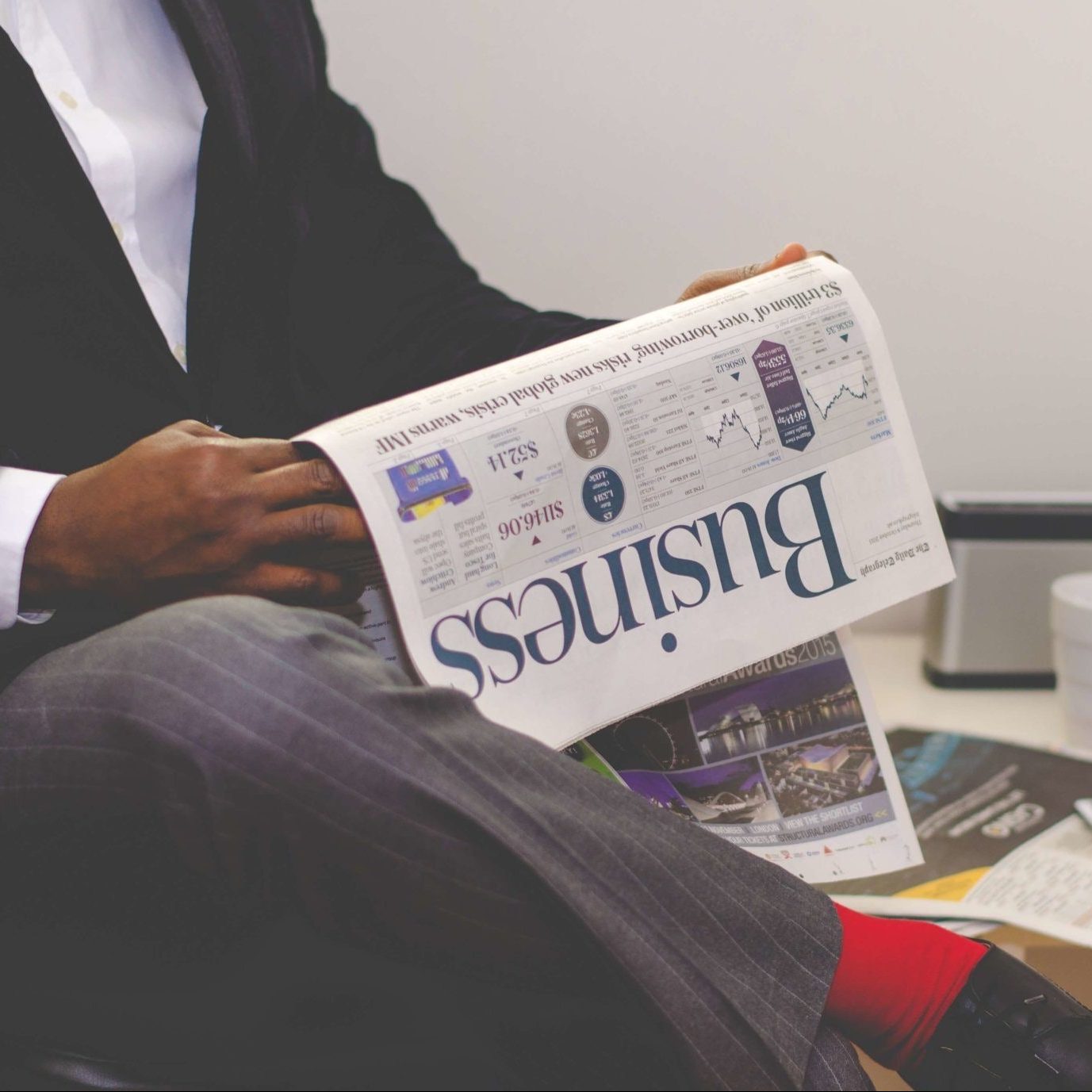 Man sitting and reading the business section of a newspaper